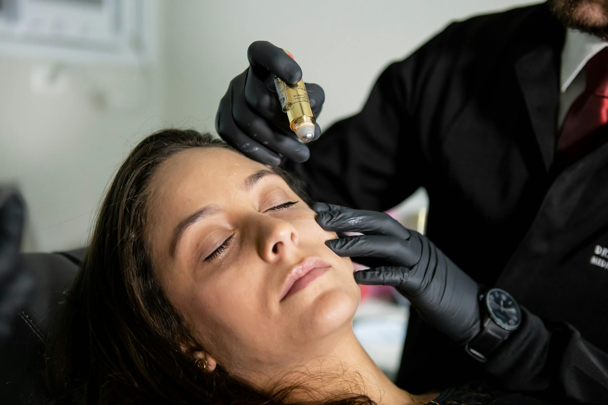 Close-up of a woman receiving a cosmetic skin care treatment in a clinic.