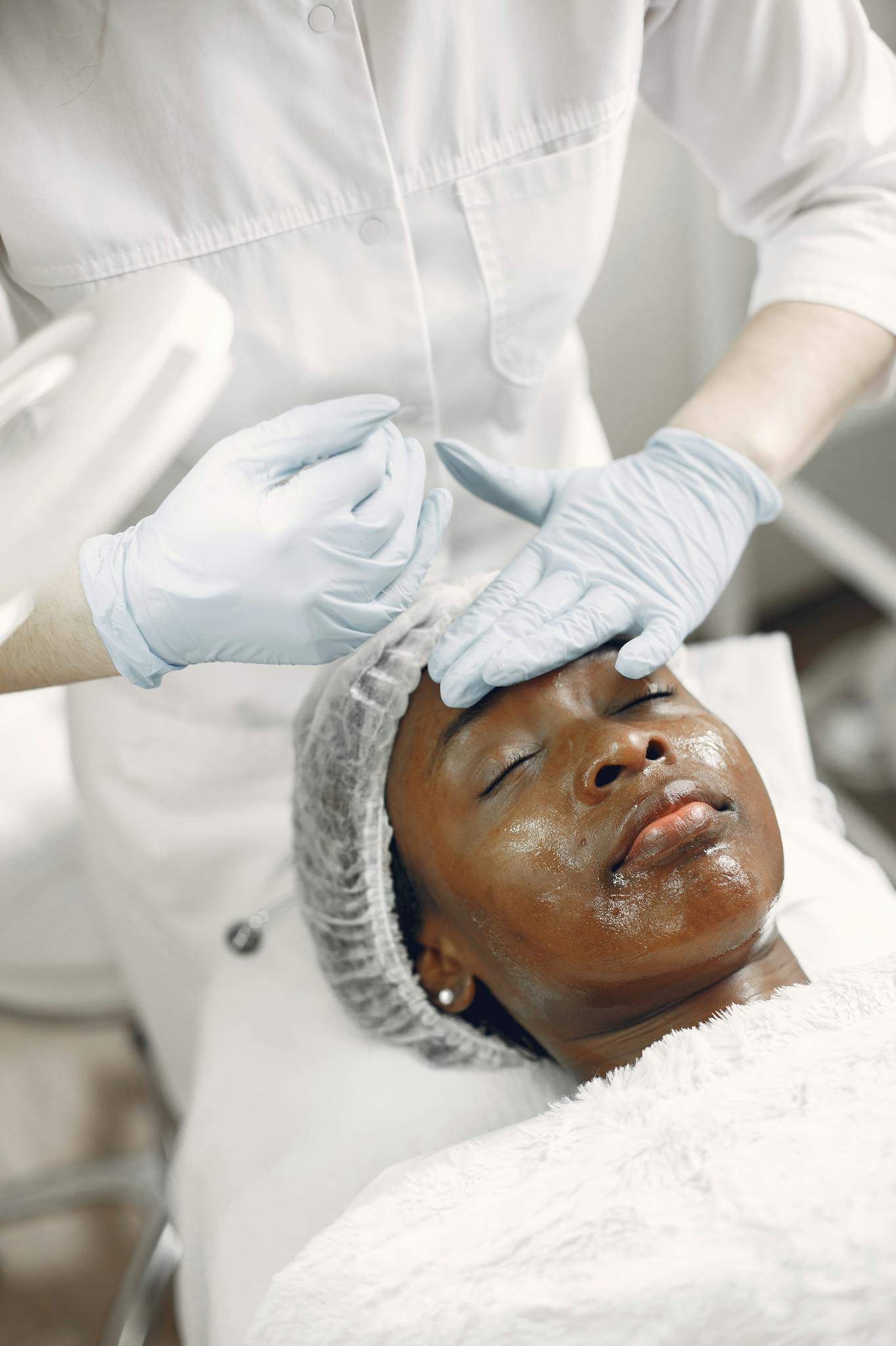 Woman receives a relaxing facial treatment in an aesthetic clinic by a professional.